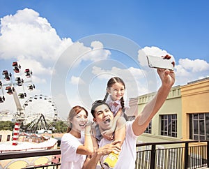 Happy family taking selfie in the park