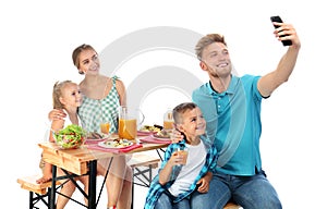 Happy family taking selfie at picnic table