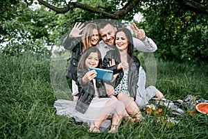 Happy family taking selfie on smartphone during picnic time