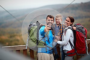 A happy family taking selfie on the top of a watchtower in the forest photo