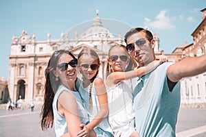 Happy family taking selfie in Vatican city and St. Peter`s Basilica church, Rome, Italy