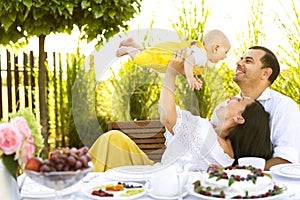 Happy family at their backyard having picnic and tea party, hugging, family values