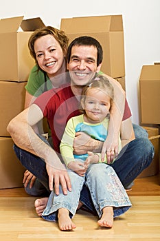Happy family in their new home with lots of boxes