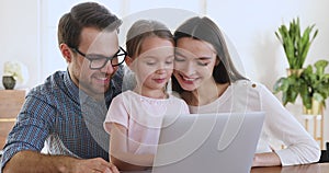 Happy family of three bonding using laptop computer at home