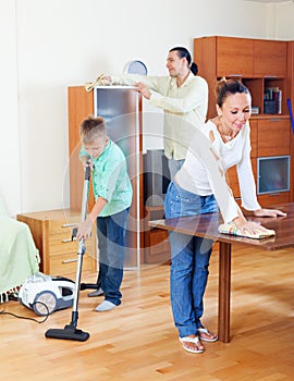 Happy family of three cleaning in home