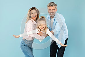 Happy Family Of Three Having Fun Posing Over Blue Background