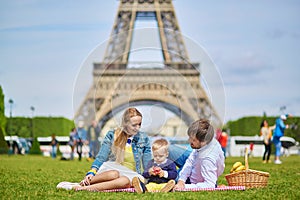 Happy family of three having picnic in Paris