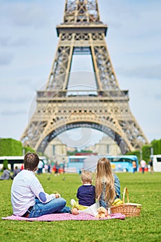 Happy family of three having picnic in Paris