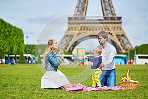 Happy family of three having picnic in Paris