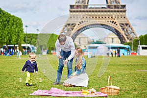 Happy family of three having picnic in Paris