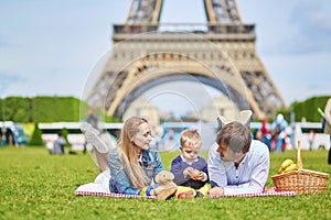 Happy family of three having picnic in Paris