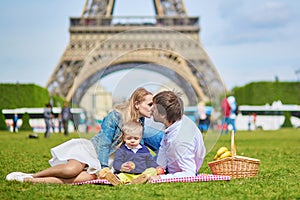 Happy family of three having picnic in Paris