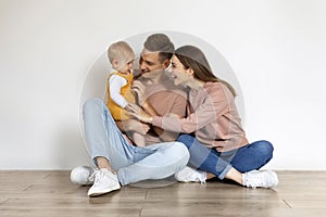 Happy Family Of Three With Infant Baby Having Fun Together At Home