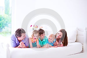 Happy family with three kids in bedroom