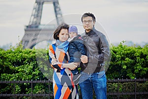 Happy family of three in Paris near the Eiffel tower