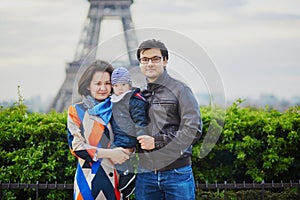 Happy family of three in Paris near the Eiffel tower