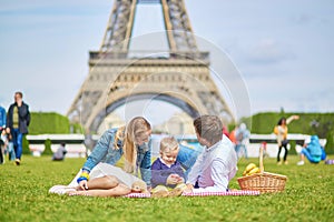 Happy family of three in Paris near the Eiffel tower