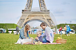 Happy family of three in Paris near the Eiffel tower