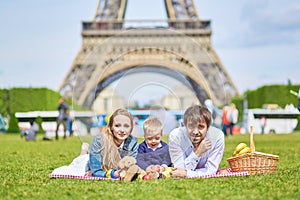 Happy family of three in Paris near the Eiffel tower