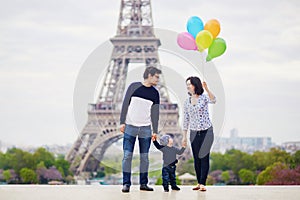 Happy family of three in Paris near the Eiffel tower