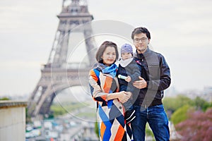 Happy family of three in Paris near the Eiffel tower