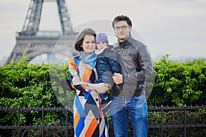 Happy family of three in Paris near the Eiffel tower