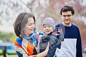 Happy family of three in Paris on a spring day