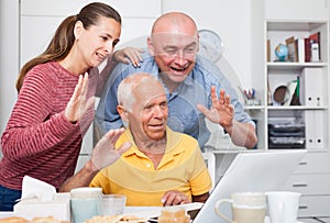 Happy family of three set up a web camera for video calls at home