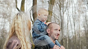 Happy family of three walking in the spring Park