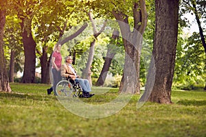 Happy family time- senior man in wheelchair and daughter in the