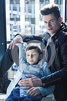 Happy family together concept, father and son at window huggings, enjoying sunlight, lifestyle people at summer