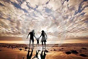 Familia feliz común mano en la mano sobre el Playa 