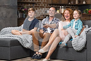 Happy Family Together Spend Time Sitting On Couch Watching TV, Cheerful Parents With Children