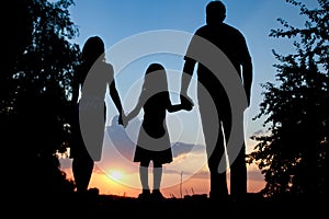 Happy family together at sunset silhouette