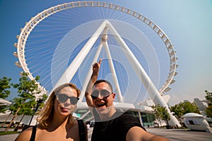 Happy family tourists couple visits Ain Eye DUBAI - One of the largest Ferris Wheels in the World, located on Bluewaters island