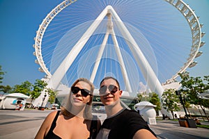 Happy family tourists couple visits Ain Eye DUBAI - One of the largest Ferris Wheels in the World, located on Bluewaters island