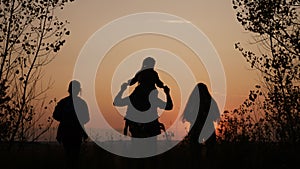 happy family tourists go hiking in park sunset silhouette. adventure travel concept. teamwork. happy family a tourists