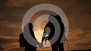 Happy family tourists walking holding hand silhouette at sunset . hikers lifestyle teamwork travel concept. man and