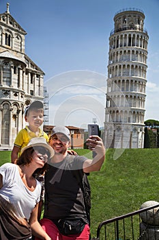 Happy family traveler taking selfie and having fun in front of the famous leaning tower in Pisa & x28;Unesco& x29;.