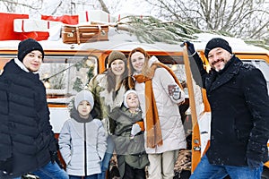 Happy family of travelers in minivan lying together at open rear doors and smiling at camera