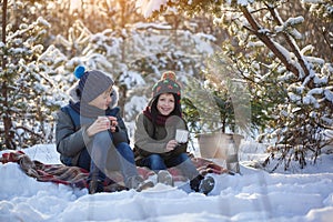 Happy family two brothers on a winter walk outdoors drinking chocolate