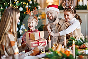 Happy family with two children celebrate Christmas at home, parents and kids exchanging xmas gifts