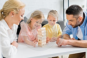 happy family with two children playing with wooden blocks at home