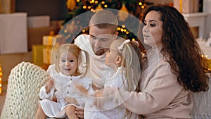 Happy family with two children sitting together in christmas interior