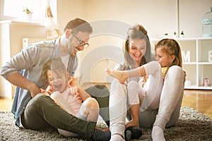 Happy family with two daughters playing at home.
