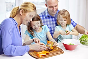 Happy family with two kids cooking at home