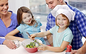 Happy family with two kids cooking at home