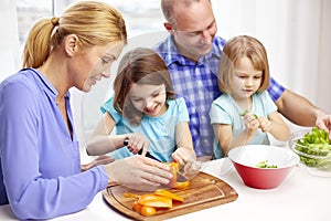 Happy family with two kids cooking at home