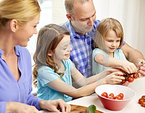 Happy family with two kids cooking at home