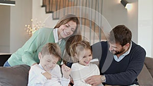 Happy family with two kids enjoy time together on couch in living room